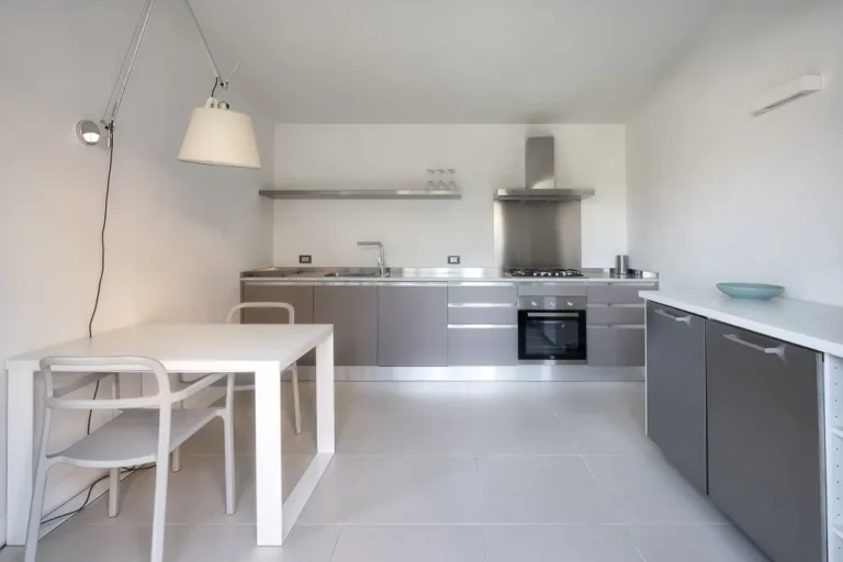 Fully equipped kitchen of the ARA garden apartment in Pietrasanta, with steel worktop, gas hob and oven