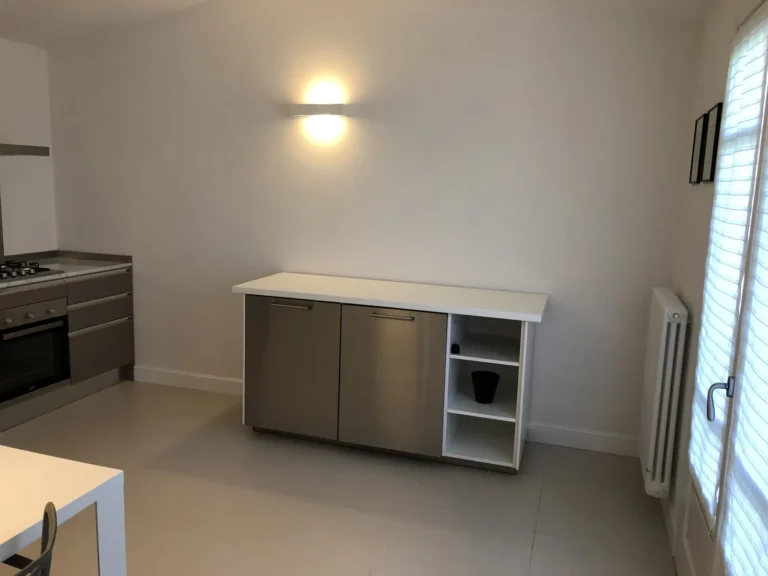 Steel and white sideboard lit by a soft wall light