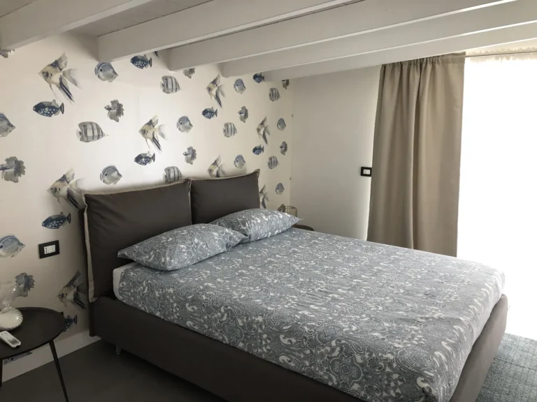 Bedroom with upholstered bed, bedside table and linen curtains